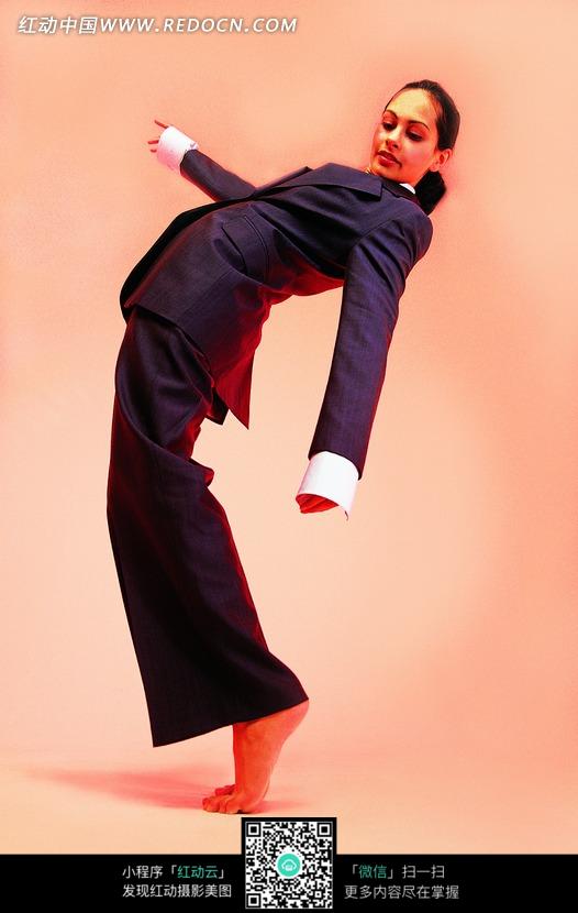 赤脚掂起脚跟甩手向后弯腰的黑衣女子图片-人