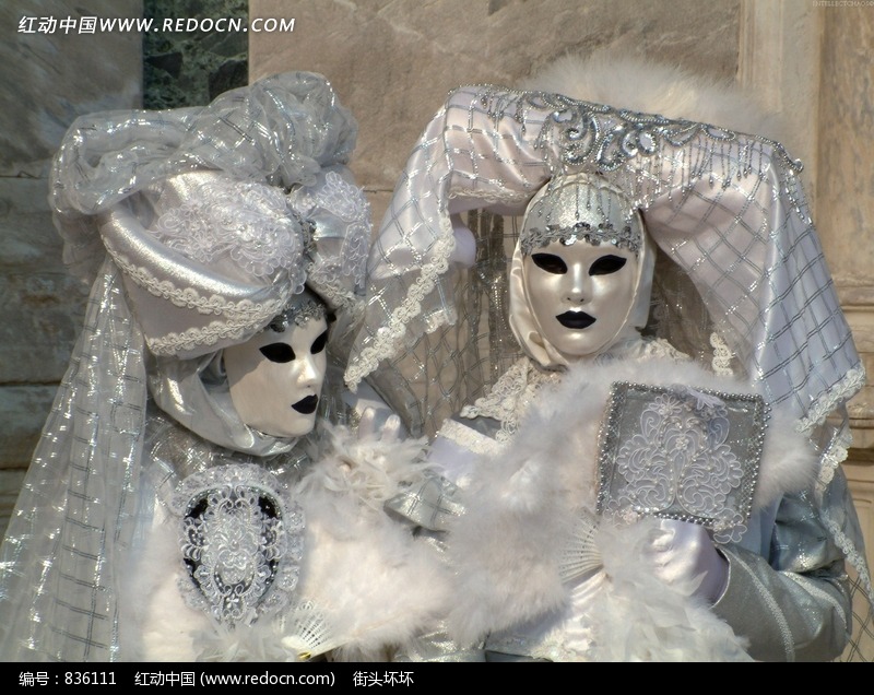 顶着夸张头饰的戴黑色嘴唇的银色面具的人物图