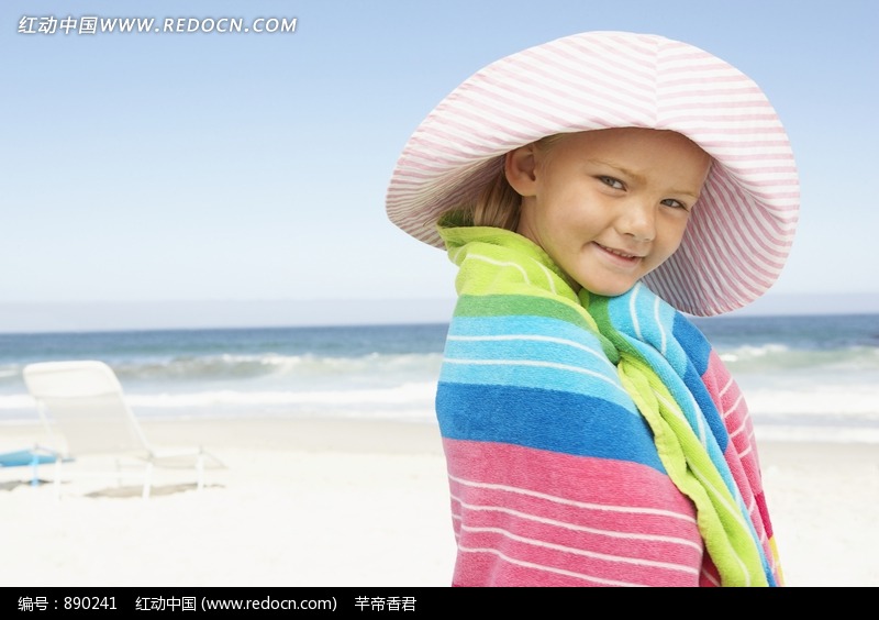 海滩上戴着帽子裹着浴巾的小女孩图片-人物图