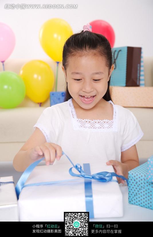 拆开白色礼盒的小女孩图片-生活用品|日常生活